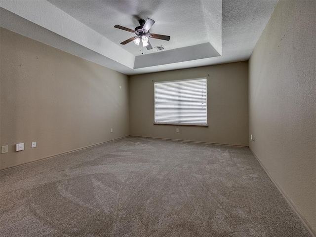 1900 New Haven Ct, Moore, OK 73160 - empty room featuring ceiling fan, a textured ceiling, a tray ceiling, and carpet floors