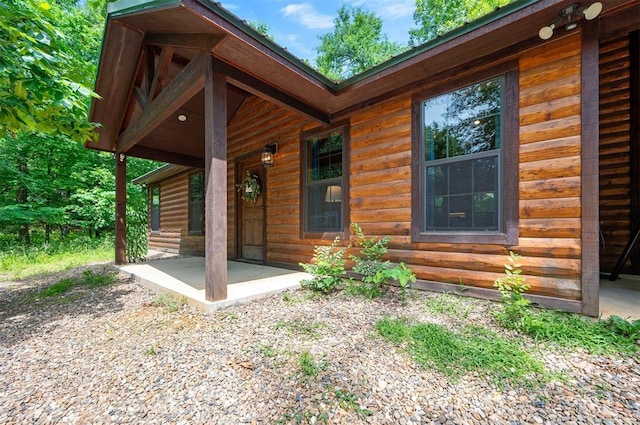 295 Orca Rd, Broken Bow, OK 74728 - doorway to property featuring a porch and faux log siding