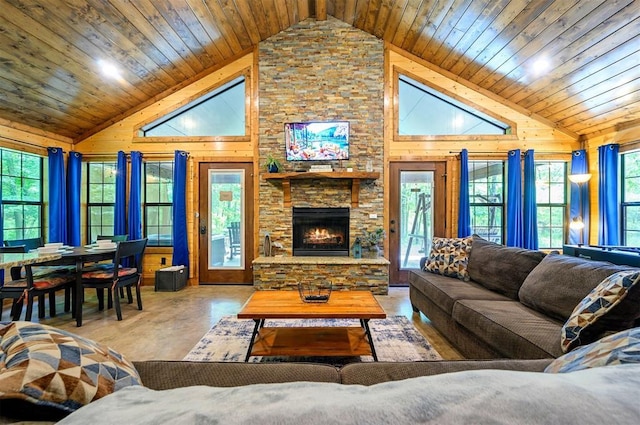 295 Orca Rd, Broken Bow, OK 74728 - living room featuring wooden walls, a stone fireplace, wood ceiling, concrete floors, and high vaulted ceiling