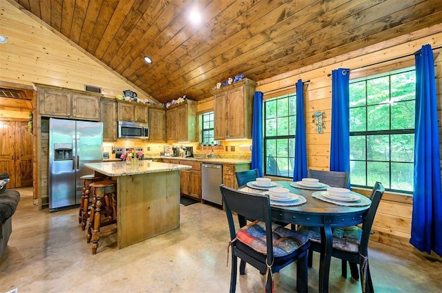 295 Orca Rd, Broken Bow, OK 74728 - kitchen featuring appliances with stainless steel finishes, wooden walls, a center island, finished concrete flooring, and wooden ceiling