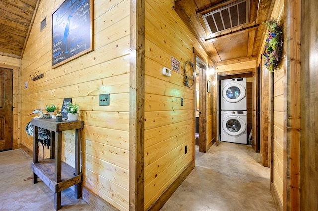 295 Orca Rd, Broken Bow, OK 74728 - corridor featuring stacked washing machine and dryer, wooden walls, and concrete floors