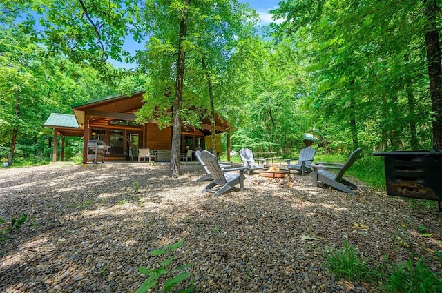 295 Orca Rd, Broken Bow, OK 74728 - view of yard with a fire pit, french doors, and a wooded view