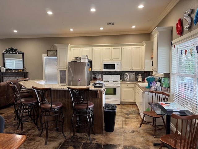 17308 Magnino Rd, Shawnee, OK 74801 - kitchen with white appliances, crown molding, backsplash, a center island, and a breakfast bar area