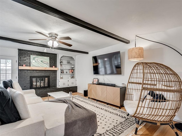 209 E Platt Dr, Yukon, OK 73099 - living room with wood finished floors, beam ceiling, a ceiling fan, built in shelves, and a fireplace