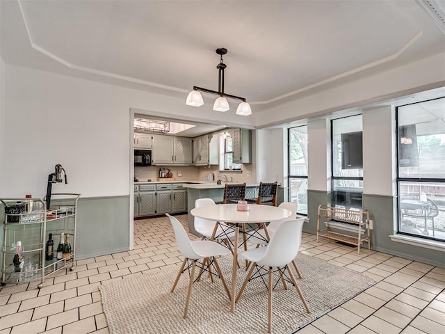 209 E Platt Dr, Yukon, OK 73099 - dining area featuring a raised ceiling, healthy amount of natural light, light tile patterned floors, and baseboards