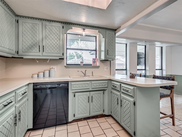 209 E Platt Dr, Yukon, OK 73099 - kitchen featuring black dishwasher, a sink, a peninsula, and light countertops