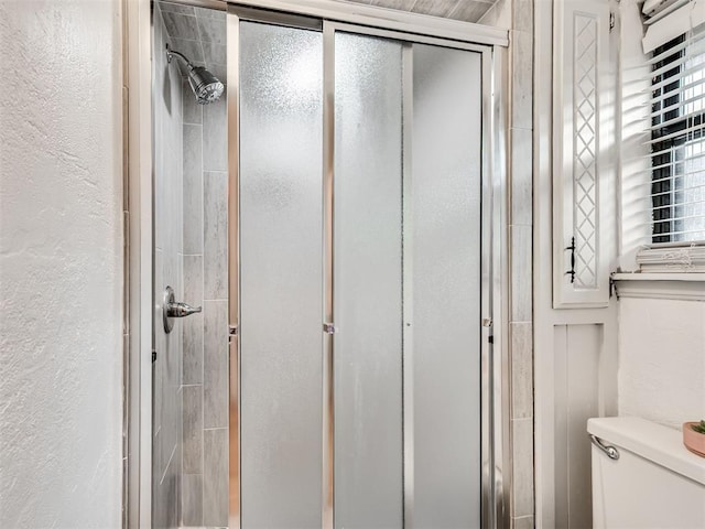 209 E Platt Dr, Yukon, OK 73099 - bathroom with a stall shower, a textured wall, and toilet