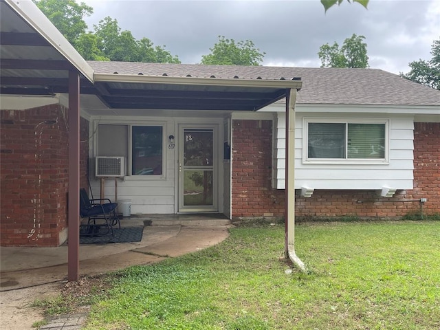 617 Mark Dr, Oklahoma City, OK 73115 - property entrance featuring roof with shingles, brick siding, a yard, and cooling unit