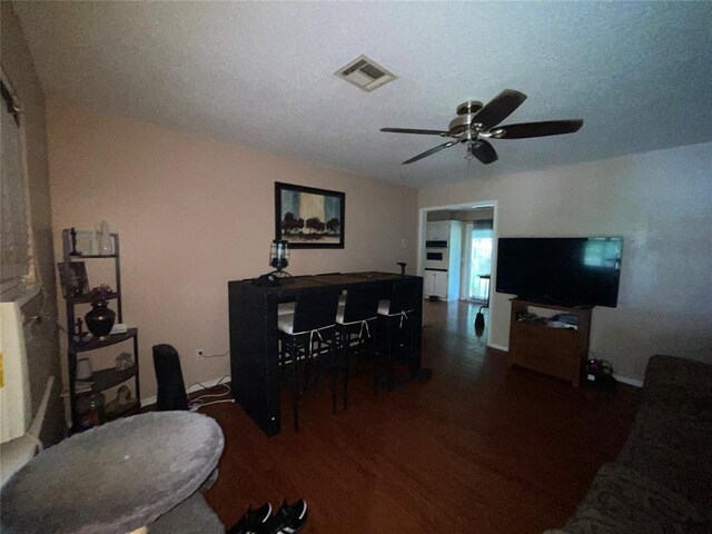617 Mark Dr, Oklahoma City, OK 73115 - living area with wood finished floors, an office area, ceiling fan, a textured ceiling, and baseboards