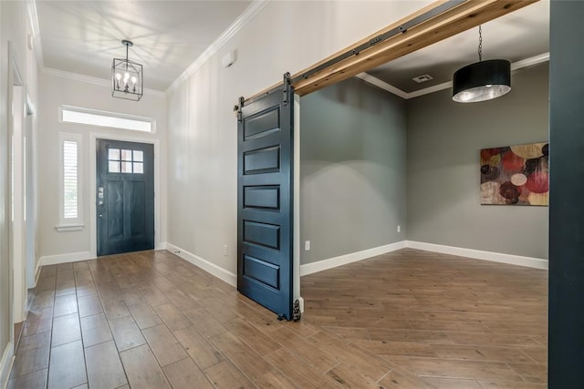 600 NW 186th St, Edmond, OK 73012 - entryway with wood finished floors, crown molding, a barn door, baseboards, and a chandelier