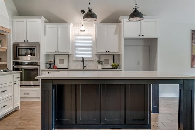 600 NW 186th St, Edmond, OK 73012 - kitchen with stainless steel appliances, light countertops, white cabinetry, and backsplash