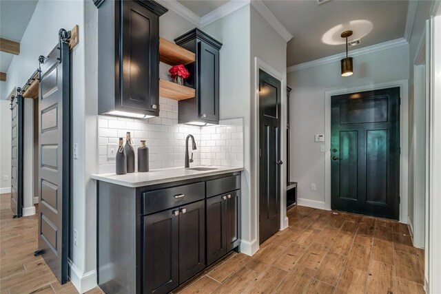 600 NW 186th St, Edmond, OK 73012 - kitchen with a barn door, open shelves, light countertops, light wood-type flooring, and decorative backsplash