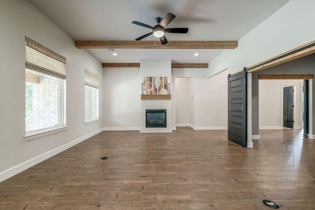 600 NW 186th St, Edmond, OK 73012 - unfurnished living room with ceiling fan, wood finished floors, a barn door, baseboards, and beamed ceiling