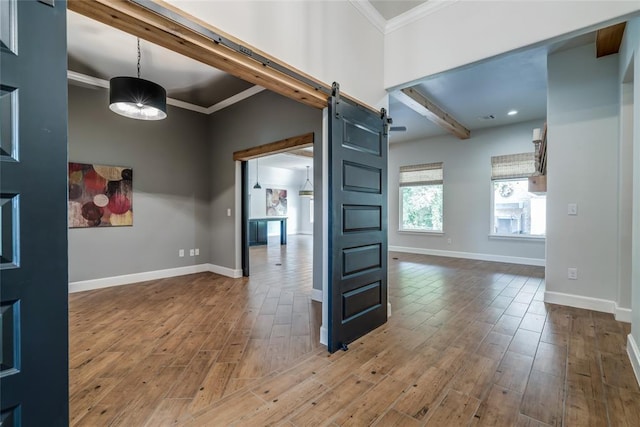 600 NW 186th St, Edmond, OK 73012 - unfurnished room with a barn door, crown molding, baseboards, wood finished floors, and beamed ceiling