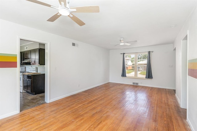 3032 NW 67th St, Oklahoma City, OK 73116 - empty room with light wood-type flooring, a ceiling fan, and baseboards
