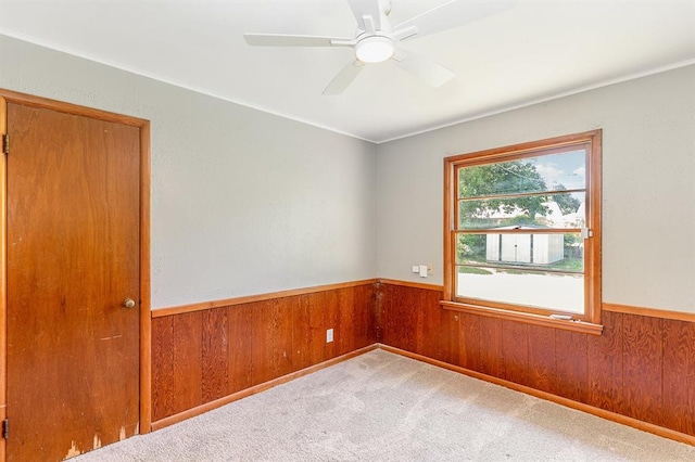 3032 NW 67th St, Oklahoma City, OK 73116 - carpeted spare room featuring wainscoting, wood walls, ceiling fan, and ornamental molding