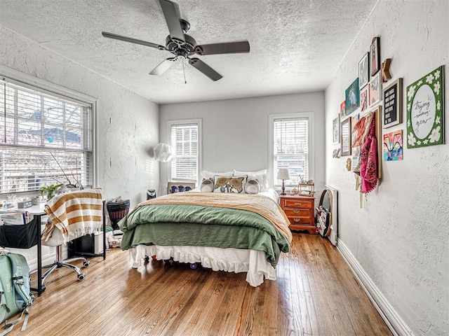 705 Chautauqua Ave, Norman, OK 73069 - bedroom featuring a textured wall, a textured ceiling, hardwood / wood-style floors, ceiling fan, and baseboards