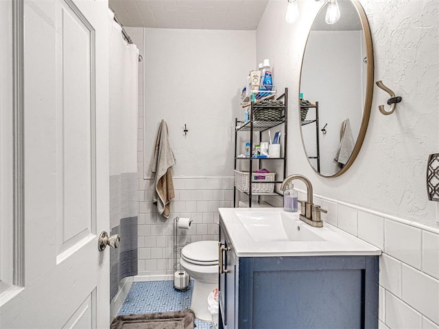 705 Chautauqua Ave, Norman, OK 73069 - bathroom featuring tile walls, vanity, wainscoting, and toilet