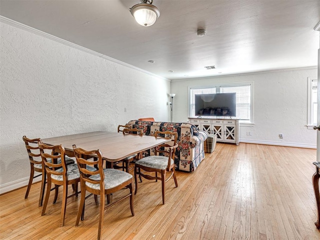 705 Chautauqua Ave, Norman, OK 73069 - dining room with a textured wall, hardwood / wood-style flooring, crown molding, and baseboards