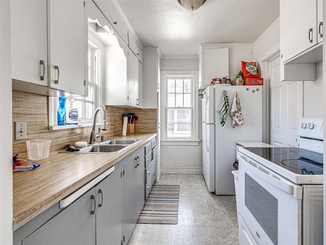 705 Chautauqua Ave, Norman, OK 73069 - kitchen with white appliances, a sink, light countertops, backsplash, and crown molding