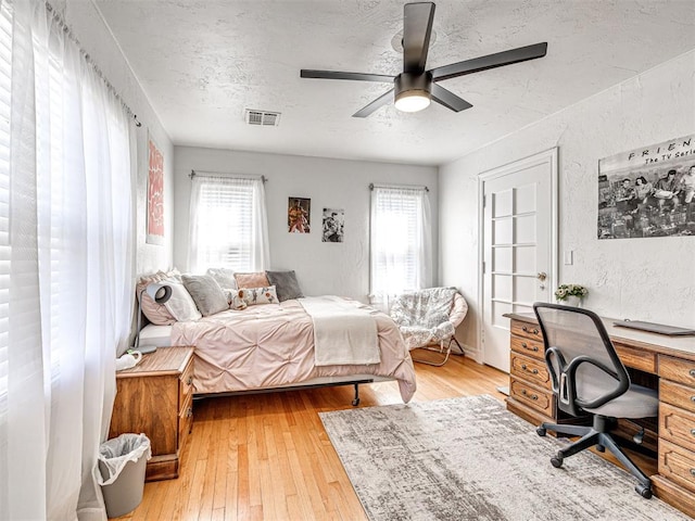 705 Chautauqua Ave, Norman, OK 73069 - bedroom with multiple windows, a textured ceiling, an office area, and hardwood / wood-style floors