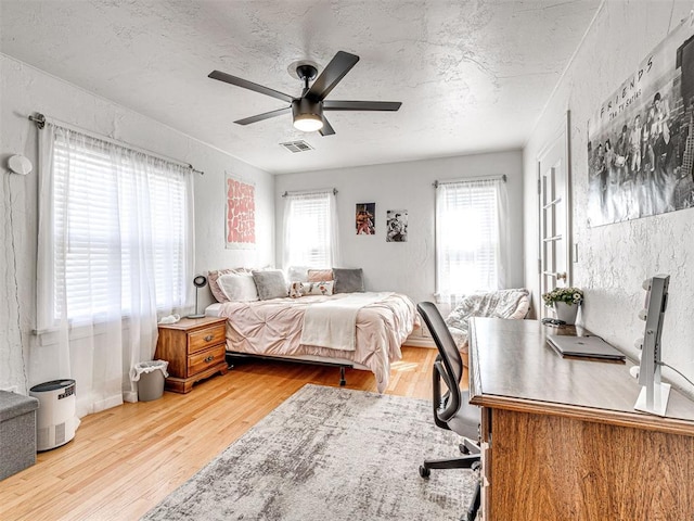 705 Chautauqua Ave, Norman, OK 73069 - bedroom with wood finished floors, a textured ceiling, and a ceiling fan