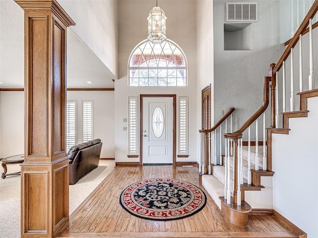 2616 Redvine Rd, Edmond, OK 73034 - foyer featuring a towering ceiling, stairway, baseboards, light wood-style flooring, and crown molding