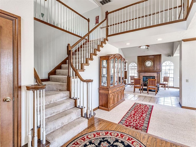 2616 Redvine Rd, Edmond, OK 73034 - stairway with baseboards, a glass covered fireplace, a high ceiling, and a ceiling fan
