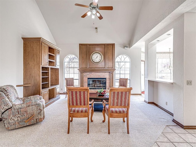 2616 Redvine Rd, Edmond, OK 73034 - dining room with light carpet, a brick fireplace, ceiling fan, baseboards, and high vaulted ceiling