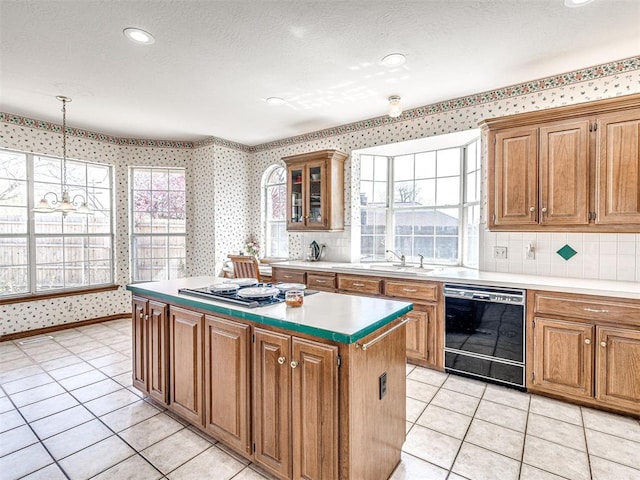 2616 Redvine Rd, Edmond, OK 73034 - kitchen with black dishwasher, cooktop, wallpapered walls, a sink, and a center island