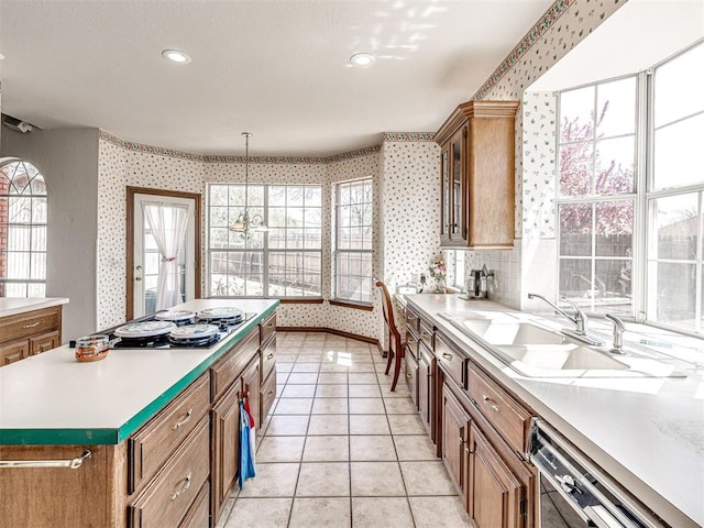2616 Redvine Rd, Edmond, OK 73034 - kitchen featuring wallpapered walls, dishwashing machine, stovetop, healthy amount of natural light, and a sink