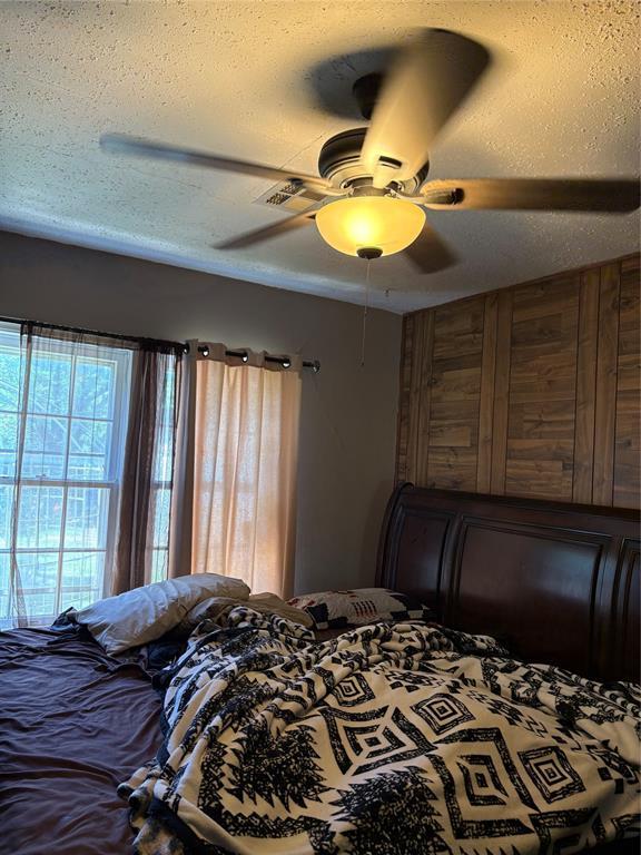 2508 N Cummings Dr, Oklahoma City, OK 73107 - bedroom with a ceiling fan and a textured ceiling