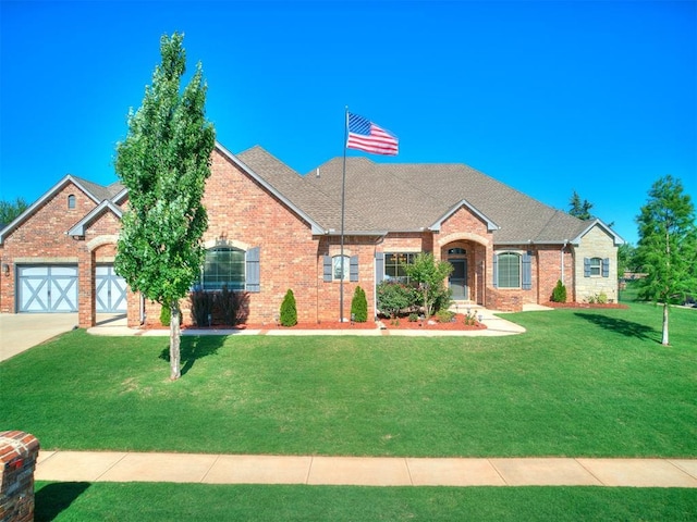 10716 Quail Reserve Rd, Oklahoma City, OK 73173 - view of front facade with a front yard, brick siding, concrete driveway, a shingled roof, and an attached garage