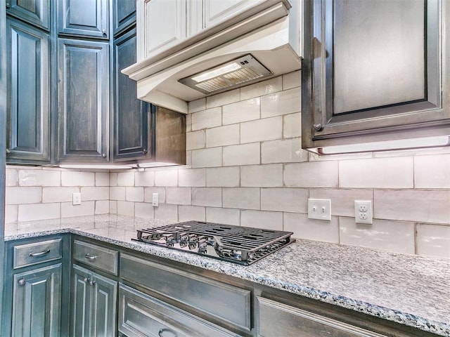 10716 Quail Reserve Rd, Oklahoma City, OK 73173 - kitchen with gas stovetop, decorative backsplash, under cabinet range hood, and light stone countertops