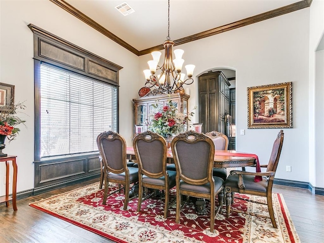 10716 Quail Reserve Rd, Oklahoma City, OK 73173 - dining space with crown molding, a chandelier, arched walkways, wood finished floors, and baseboards