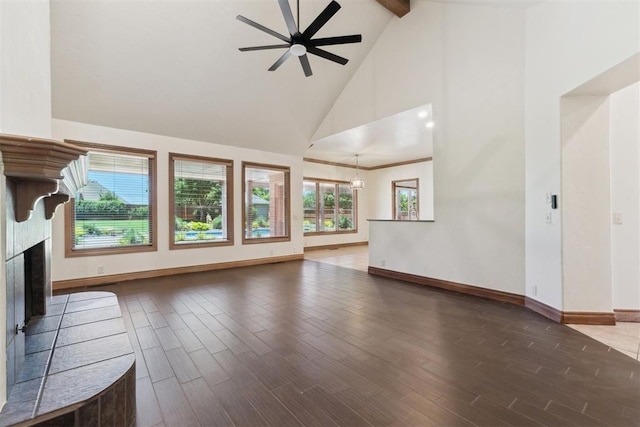 18617 Wolf Creek Dr, Edmond, OK 73012 - unfurnished living room featuring high vaulted ceiling, baseboards, beam ceiling, ceiling fan, and a fireplace