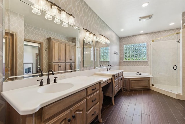 18617 Wolf Creek Dr, Edmond, OK 73012 - bathroom featuring vanity, a garden tub, a shower stall, wood finished floors, and wallpapered walls