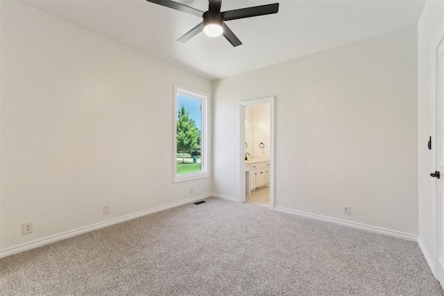 18617 Wolf Creek Dr, Edmond, OK 73012 - unfurnished bedroom with light colored carpet, baseboards, ensuite bath, and a ceiling fan