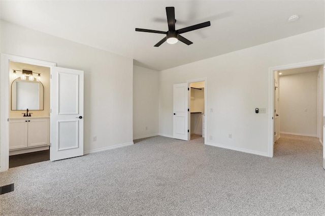 18617 Wolf Creek Dr, Edmond, OK 73012 - unfurnished bedroom with carpet floors, baseboards, ensuite bathroom, a spacious closet, and a ceiling fan