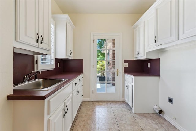 18617 Wolf Creek Dr, Edmond, OK 73012 - washroom featuring cabinet space, hookup for an electric dryer, light tile patterned floors, and baseboards