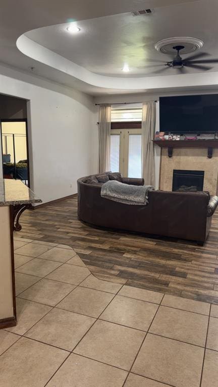 928 County St Unit 2932, Tuttle, OK 73089 - living area with tile patterned floors, a fireplace, a tray ceiling, and a ceiling fan
