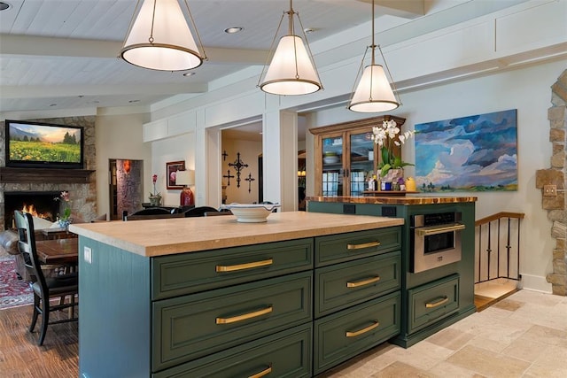 6638 Avondale Dr, Nichols Hills, OK 73116 - kitchen featuring green cabinetry, butcher block counters, a fireplace, stainless steel oven, and beam ceiling