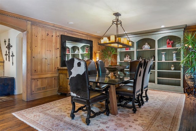6638 Avondale Dr, Nichols Hills, OK 73116 - dining space with arched walkways, wood finished floors, wooden walls, and crown molding