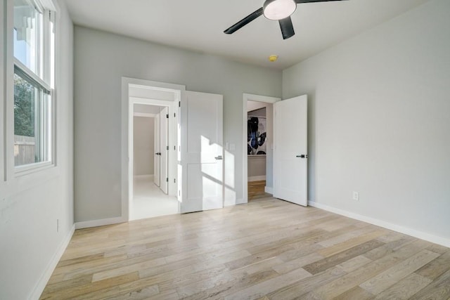 108 NW 25th St, Oklahoma City, OK 73103 - unfurnished bedroom featuring light wood-type flooring, baseboards, a ceiling fan, and a spacious closet
