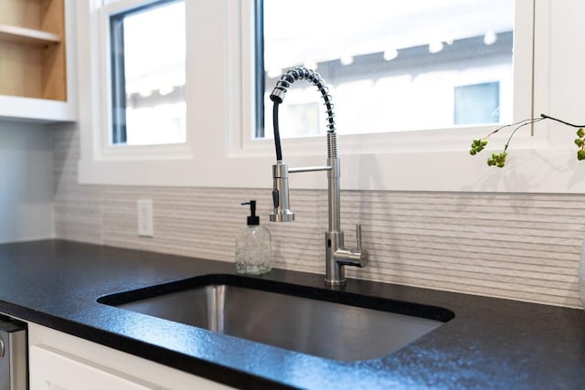 108 NW 25th St, Oklahoma City, OK 73103 - kitchen view of a sink, decorative backsplash, white cabinets, and dark countertops