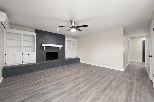 7 Concord Blvd, Shawnee, OK 74804 - unfurnished living room featuring ceiling fan, an AC wall unit, baseboards, and light wood-style floors
