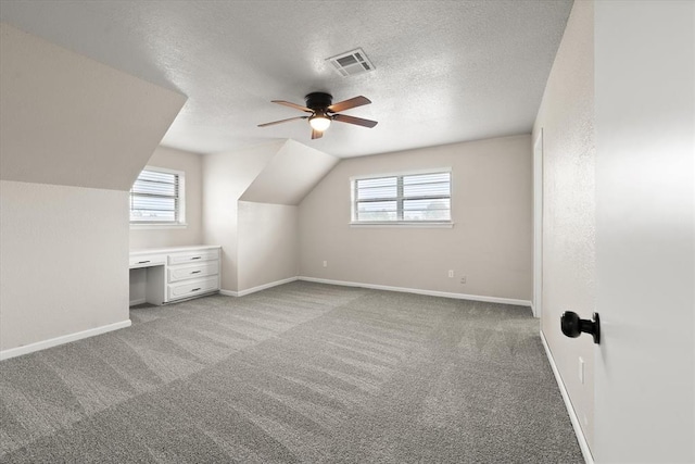7 Concord Blvd, Shawnee, OK 74804 - additional living space with healthy amount of natural light, a ceiling fan, light colored carpet, a textured ceiling, and vaulted ceiling