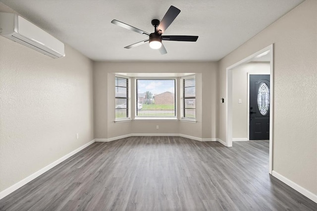 7 Concord Blvd, Shawnee, OK 74804 - empty room with an AC wall unit, wood finished floors, baseboards, and a ceiling fan