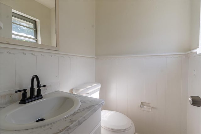 1524 Hampton Dr, Del City, OK 73115 - bathroom with toilet, vanity, a decorative wall, and a wainscoted wall