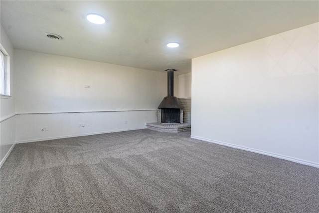 1524 Hampton Dr, Del City, OK 73115 - unfurnished living room with a wood stove, carpet flooring, baseboards, and recessed lighting